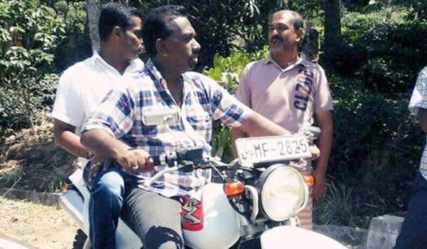 Mahindananda motorcycling in his home village