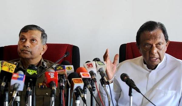 Sri Lankan Minister of Public Order, Disaster Management and Christian Affairs, John Amaratunga (R) speaks as Sri Lankan police chief N.K. Illangakoon looks on during a press conference in Colombo on February 26, 2015 