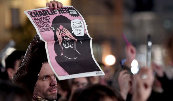 A man holds a Charlie Hebdo&#039;s front page reading &quot;Muhammad overwhelmed by fundamentalists ; It&#039;s hard to be loved by fools&quot; during a gathering in front of the city hall of Rennes, western France, on January 7, 2015. (Damien Meyer/AFP/Getty Images)